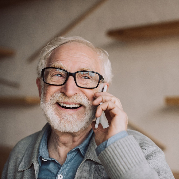 Senior man with glasses talking on phone