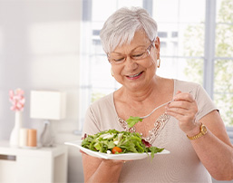 Senior woman with glasses eating a salad