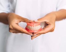 Lady presents viewer with dentures